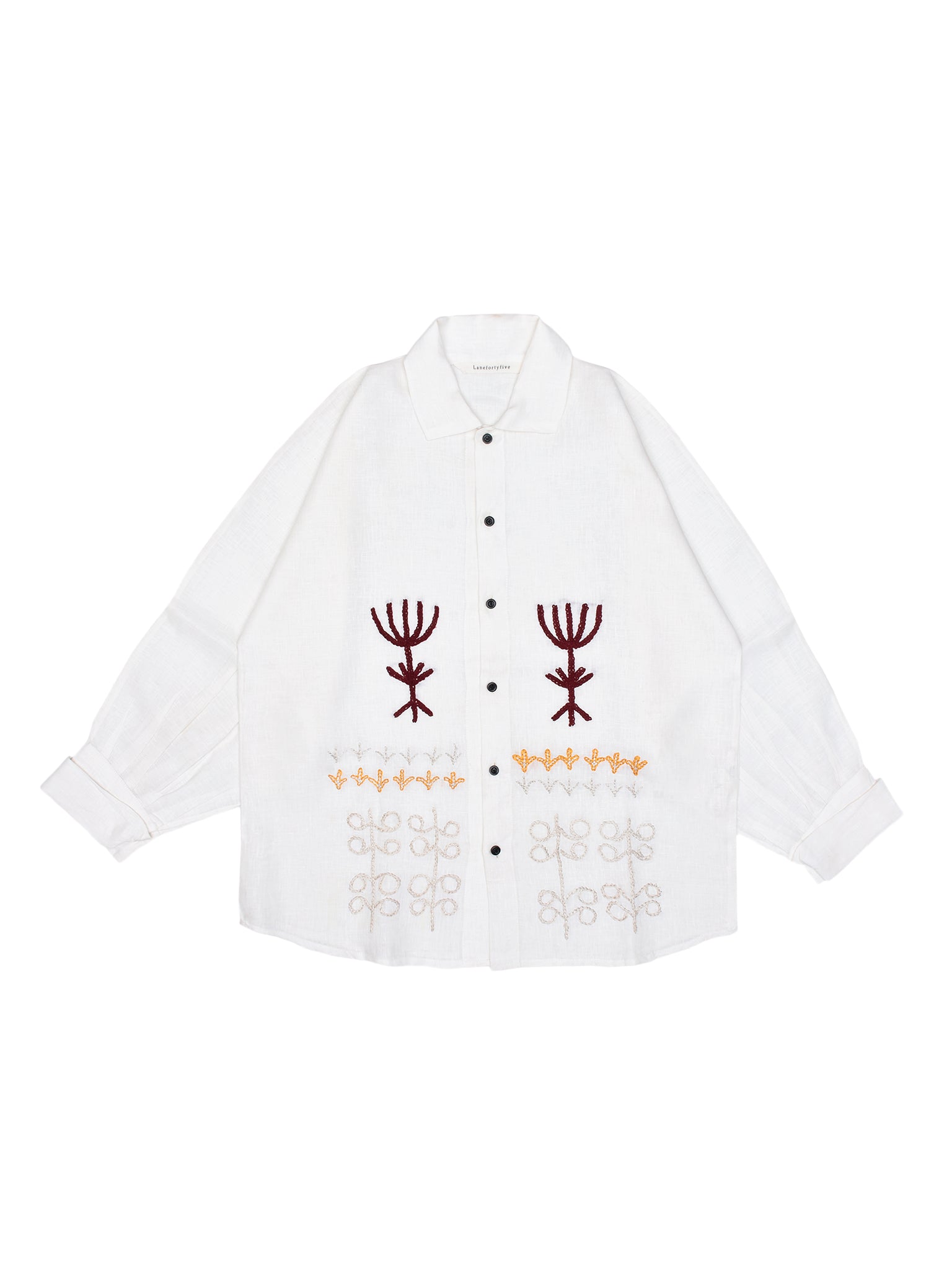 White shirt with embroidered designs on a white background