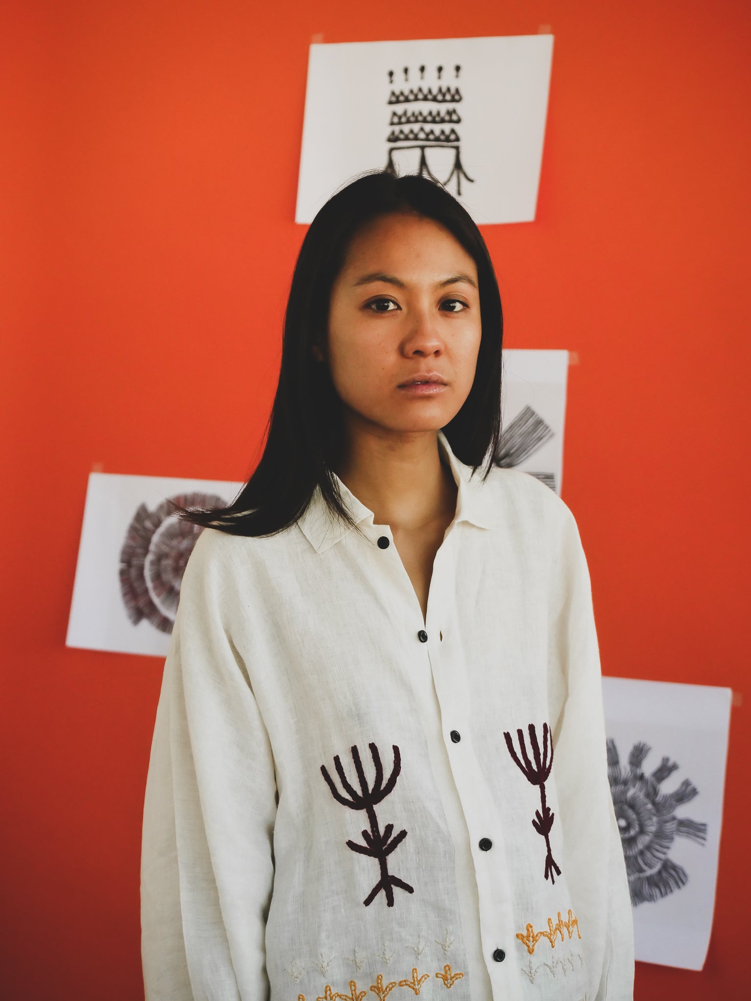 Person wearing a white shirt with embroidery on it