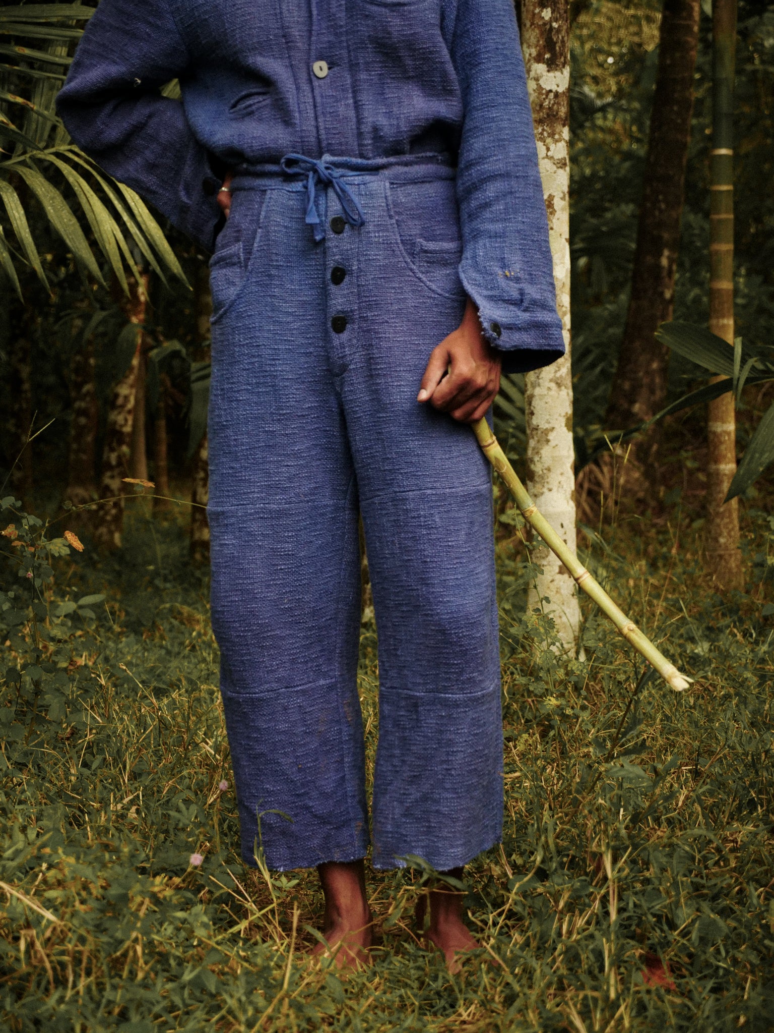 Person wearing a blue outfit standing in a forest
