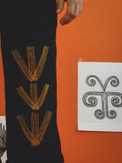 Navy trousers with hand embroidery on an orange background