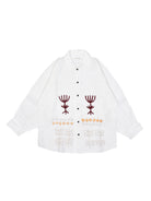 White shirt with embroidered designs on a white background