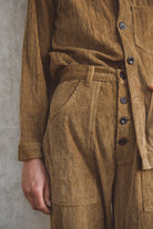 Brown corduroy suit with a belt against a gray background
