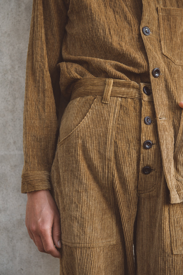 Brown corduroy suit with a belt against a gray background