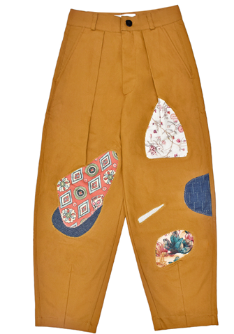 Mustard brown pants with colorful patchwork design on a white background