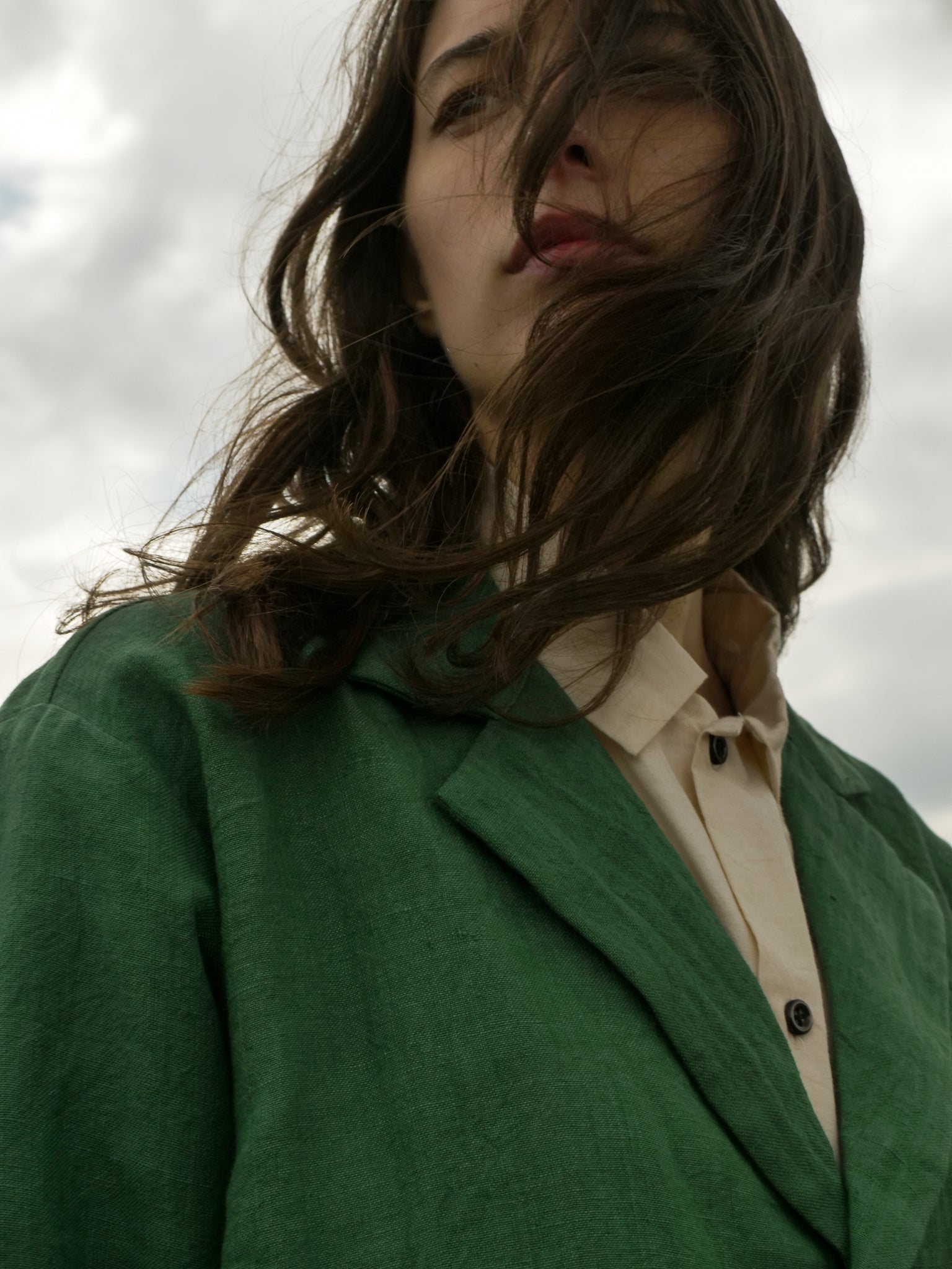 Person wearing a green coat with a neutral background