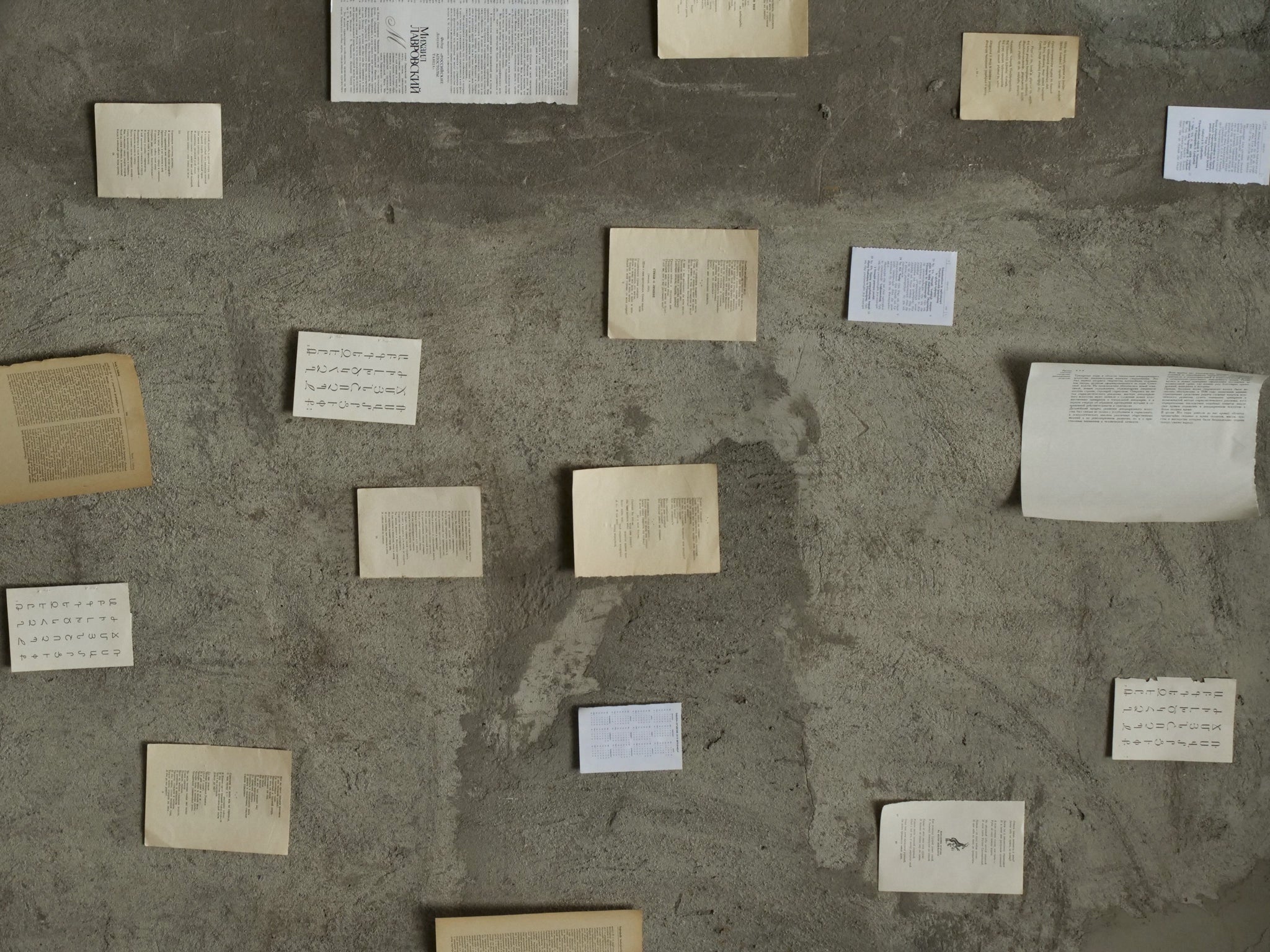 Scattered pages of a book on a textured wall