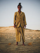 Person wearing a mustard suit standing in a desert landscape