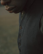 Close-up of a dark textured fabric with buttons on a blurred background