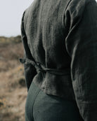 Person wearing a black vest with a belt in an outdoor setting