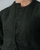 Black garment with buttons on a plain background