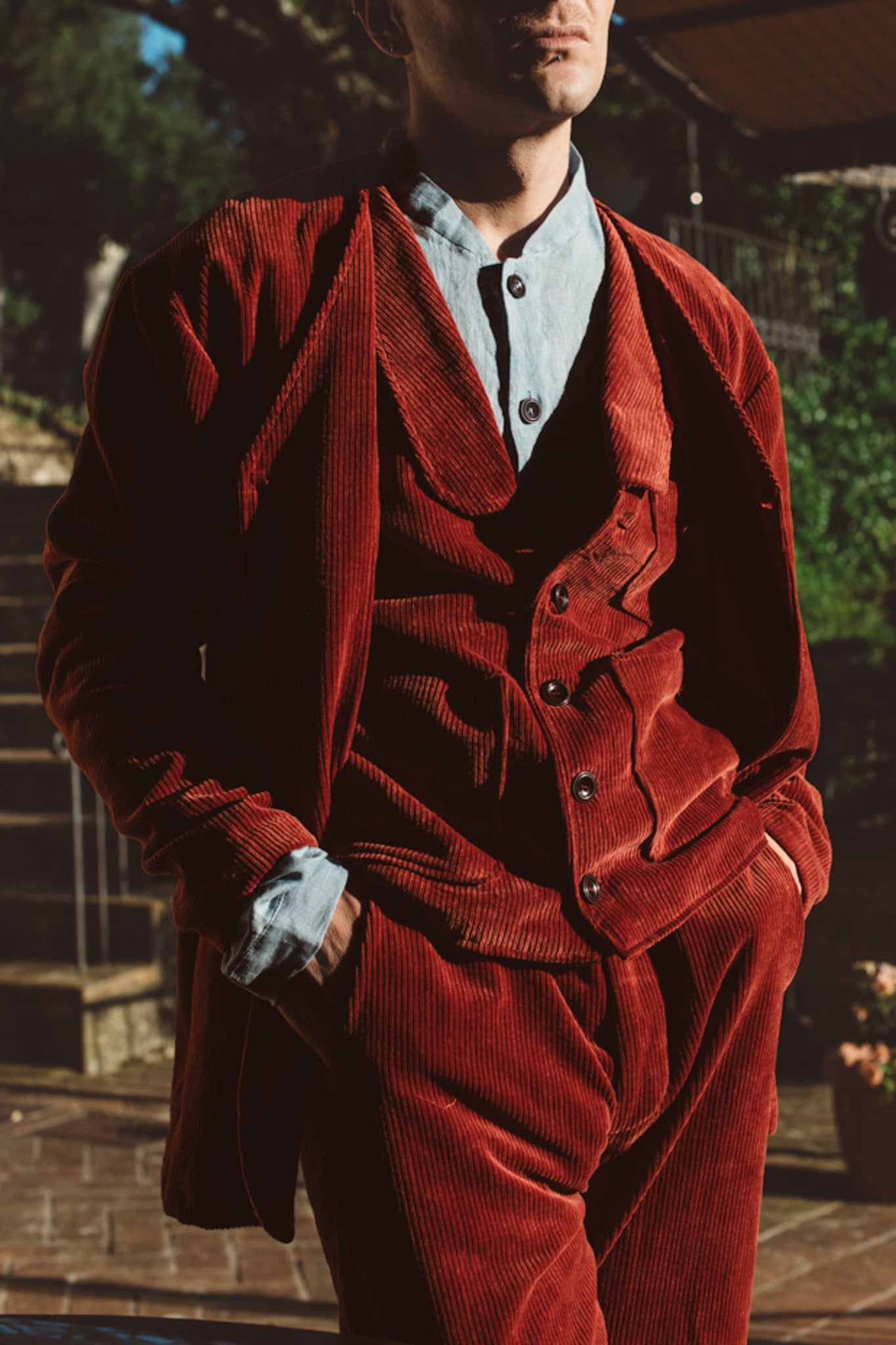 Person wearing a red corduroy suit with a blurred background