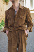Person wearing a brown corduroy outfit standing outdoors.