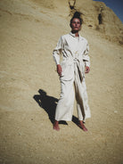 Person wearing a white outfit standing in a desert landscape