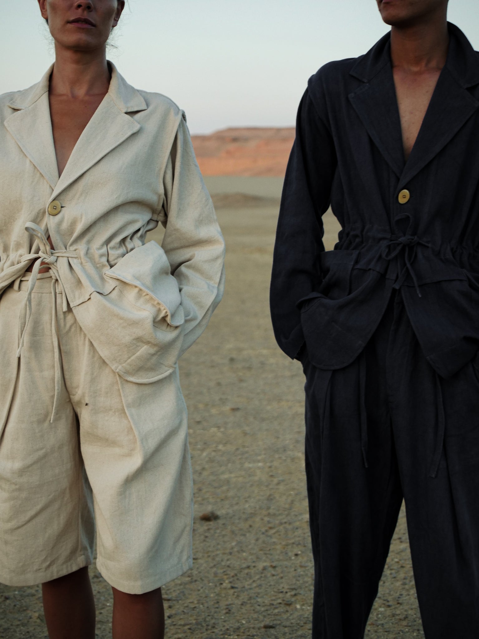 Two people wearing suits in a desert setting