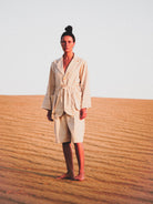 Person wearing a white outfit standing in a desert landscape
