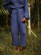 Person wearing a blue outfit standing in a forest